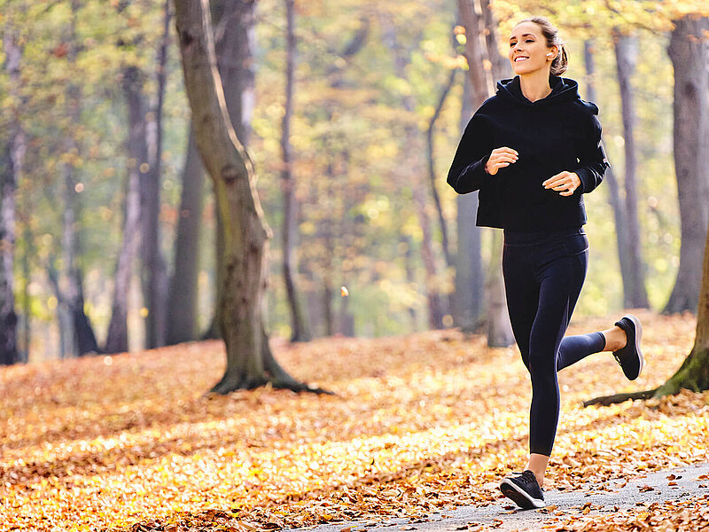 Eine Frau joggt durch einen Wald